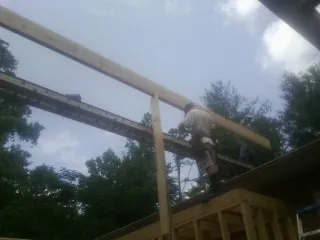 Carpenter setting a ridge beam over a new addition frame — Ice Dam Removal by Roofing Brothers in Richwood
