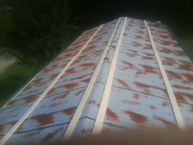 Rusted metal roof panels with new wood purlins before replacement — Storm Damage Roof Repair in Richwood by Roofing Brothers