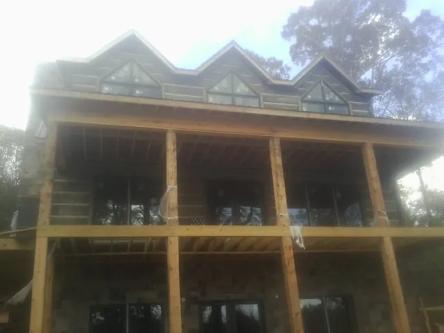 Dormers and porch framing on a large log home under construction — Roof Coating work by our crew in Richwood