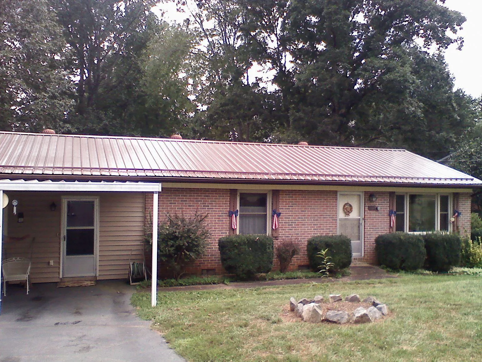 Bronze metal roof and carport on a brick ranch home — Roof Repair work by our crew in Richwood